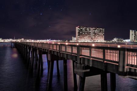 Bridge on Body of Water Near High Rise Building during Night Time Photo