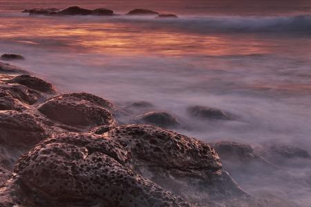 Brown and Black Rock Formations With Fog during Sunset