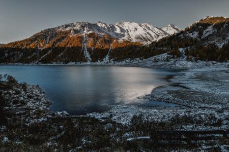 Brown and White High Rise Mountain Beside of Body of Water