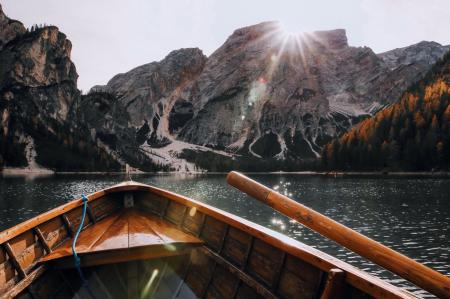 Brown Canoe in the Body of Water Near Mountain