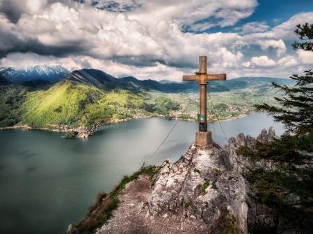 Brown Cross Near Body of Water Under White Sky