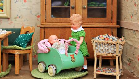 Brown Haired Girl Doll Holding Baby in Bassinet Doll