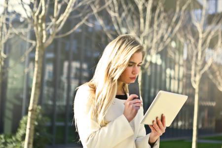 Brown-haired Woman Holding a White Wireless Device