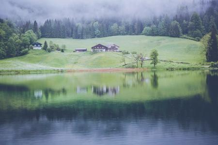 Brown House on Green Grass Meadows Near Body of Water