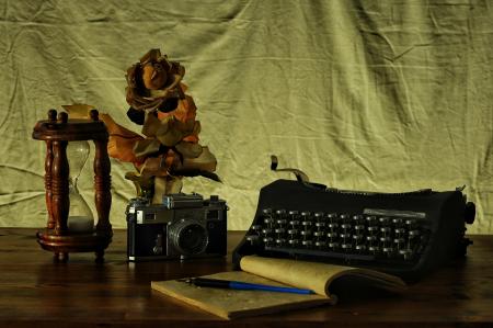 Brown Notebook in Between of a Type Writer and Gray and Black Camera