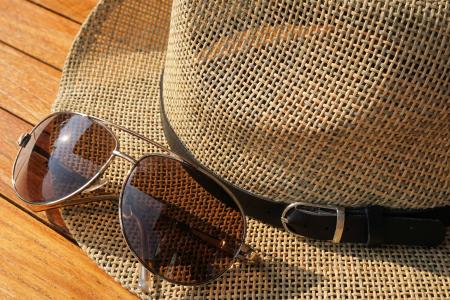 Brown Strawhat Beside Brown Aviator Sunglasses