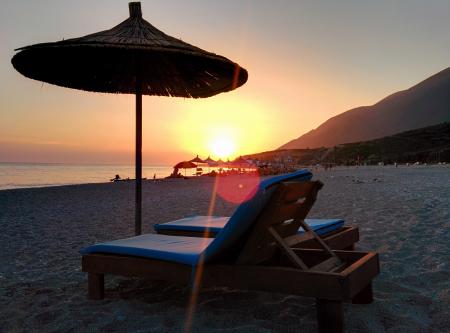 Brown Wooden Lounger on Seashore during Day Time