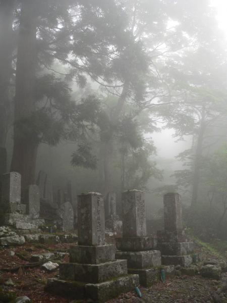 Buddhist gravestones in the mist at a mountain temple