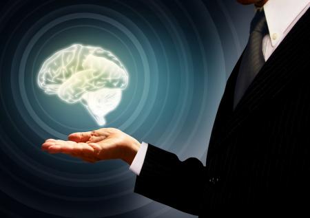 Businessman holding a brain in the palm - Skills concept - Concentric