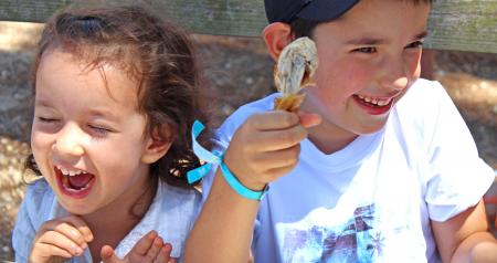 Children eating chicken with their hands