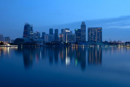 City Buildings Beside Body Of Water During Night Time