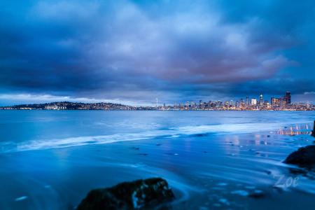 City Buildings Near Body of Water Under Gray Clouds