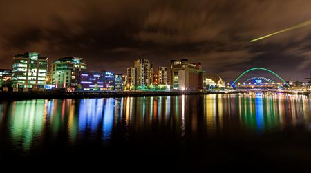 Cityscape at Nighttime Reflecting on Body of Water