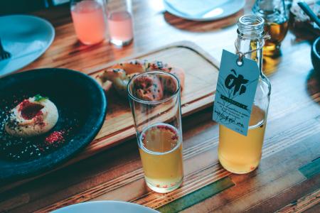 Clear Glass Bottle and Drinking Glass With Brown Liquid