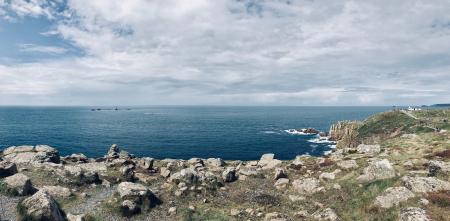 Cliff And Body Of Water Under Cloudy Sky