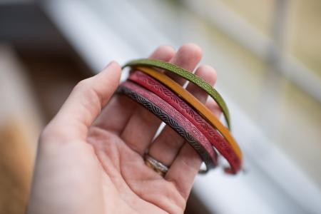 Close-up of Human Hand Holding Multi Colored Bracelets