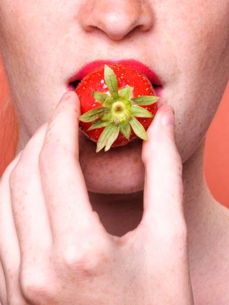 Close up woman mouth eating strawberry
