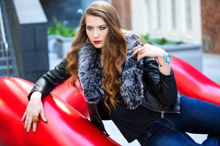 Closeup Photo of Woman Wearing Black Leather Fur-lined Jacket and Blue Denim Bottoms