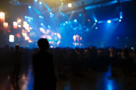 Concert crowd in front of bright stage
