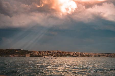 Concrete Buildings Near Sea Under White and Blue Cloudy Sky