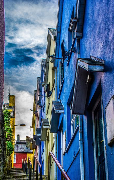 Concrete Steps Beside Blue, Yellow, and Purple Concrete Structures Under Cloudy Sky