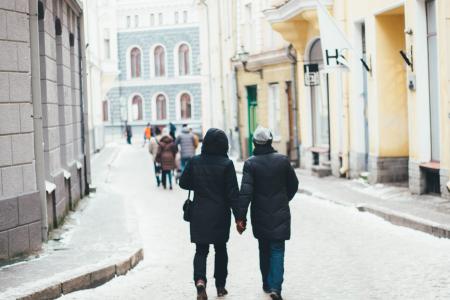 Couple Holding Hands Between of High Rise Building at Daytime