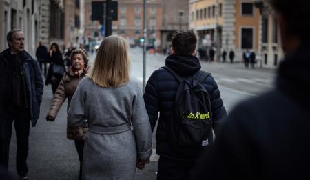 Couple Holding Hands While Walking on the Street