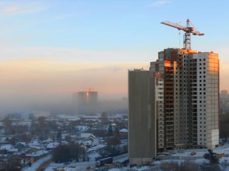 Cranes and buildings in fog