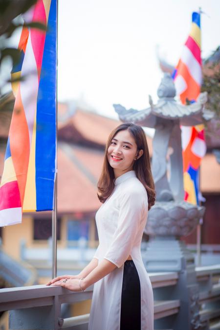 Depth of Field Photo of Woman Wearing White Dress Standing Near Flag Pole