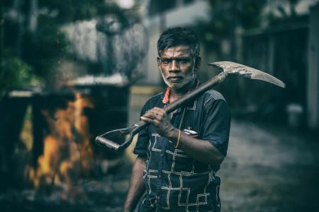 Depth of Field Photography of Man in Black Shirt Holding Shovel