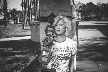 Female Leaning on Gray Concrete Post Grayscale Photo