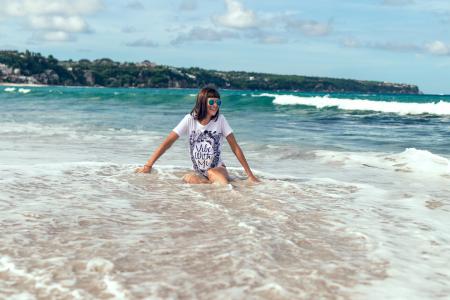 Female Sitting on Beach Shore Wearing White Shirt