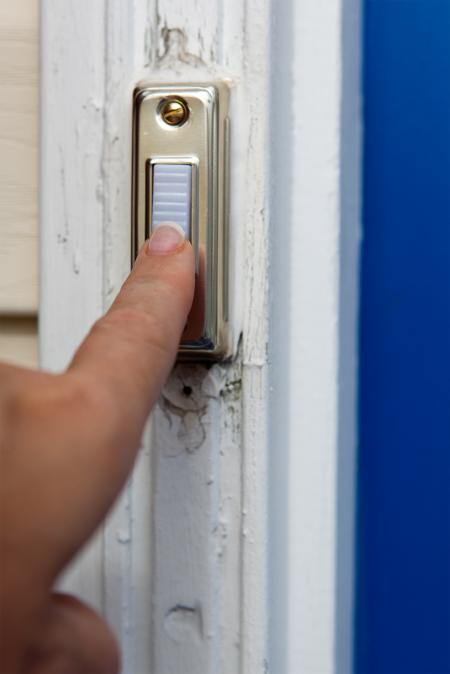 Finger pressing a doorbell