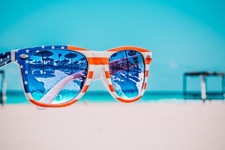 Focus Photography of American Flag-accent Wayfarer-styled Sunglasses With Sea Background