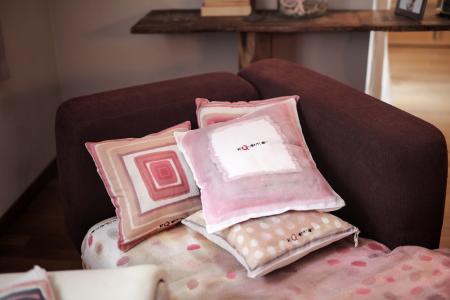 Four Assorted-color Throw Pillows on Padded Red Sofa