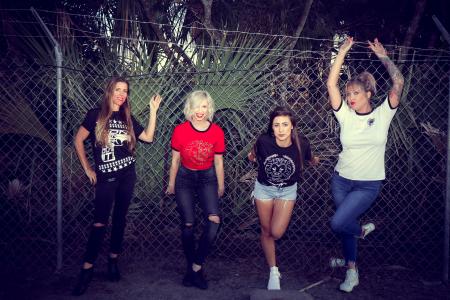 Four Woman Leaning on Chain Link Fence