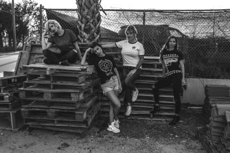 Four Women Leaning and Sitting on Pallets