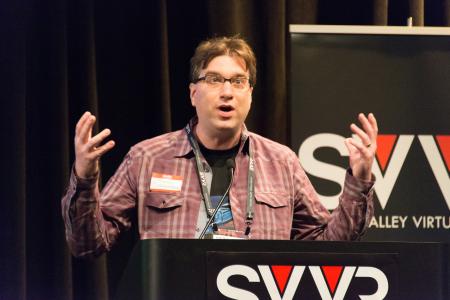 Frank Nora (developer of Nightstation, representing New York City VR Meet-Up) giving 60 Second Pitch at SVVR (eyes/mouth open wide and hands raised)