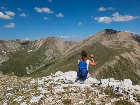 Friends Standing on Mountain Against Blue Sky