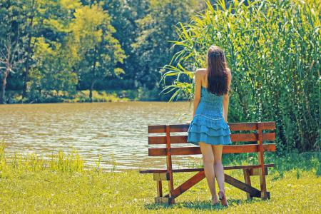 Full Length Rear View of a Woman Overlooking Calm Lake