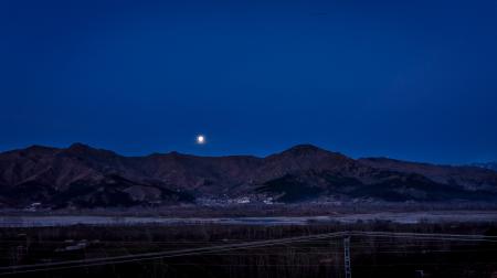 Full Moon Above the Mountain Ranges Near Town