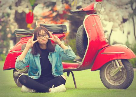 Girl Doing Peace Sign Indian Sitting in Front of Red Scooter Motorcycle