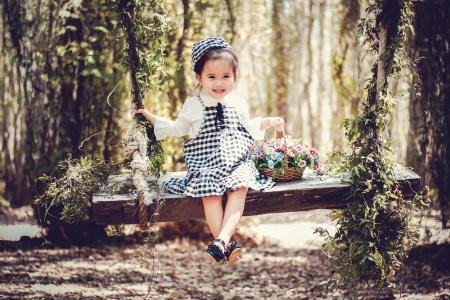 Girl in Black and White Overall Skirt Holding Basket With Petaled Flowers