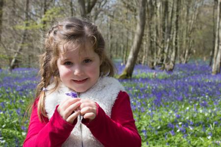 Girl in Red and Beige Jacket Holding Purple Petaled Flower