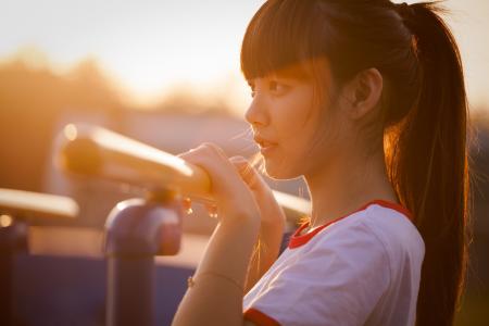 Girl in White and Red Ringer Crew Neck T Shirt Holding Metal Railing at Daytime