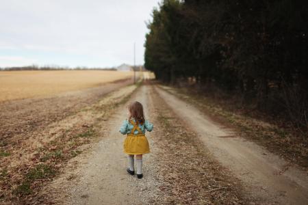 Girl Wearing Blue Long-sleeved Shirt and Yellow Skirt Walking on Pathway