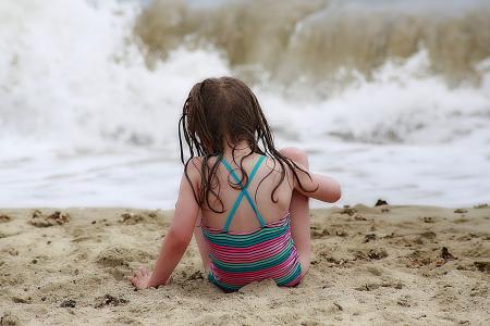 Girl Wearing Colorful Halter Top Swim Wear Sitting on a Brown Sand