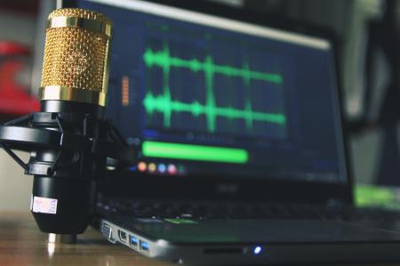 Gold Condenser Microphone Near Laptop Computer
