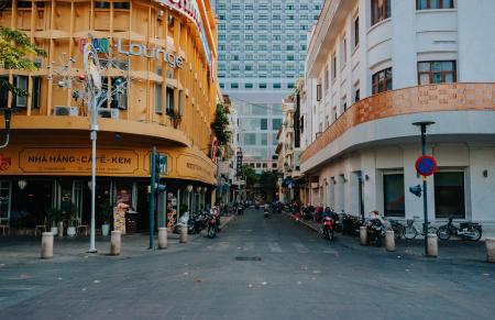 Gray Asphalt Street in Between Yellow and White Concrete Buildings at Daytime