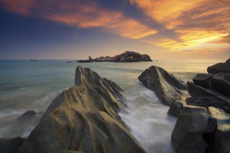 Gray Rock Formation Near Body of Water during Sunset